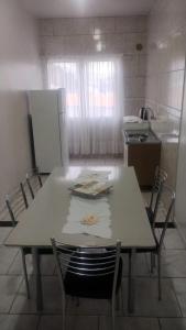a kitchen with a table with chairs and a refrigerator at Pousada Familiar 09 in Rio do Sul +2 photos