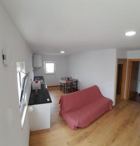 a kitchen and a living room with a red couch at T1TR Anciao in Ancião