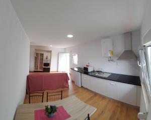 a kitchen with a table and a kitchen with a counter top at T1TR Anciao in Ancião