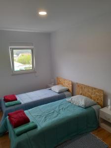 a bedroom with two beds and a window at T1TR Anciao in Ancião