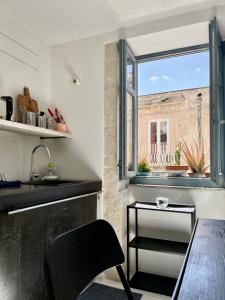 cocina con mesa y ventana en Vittorio Veneto by Bed&Bros, en Siracusa
