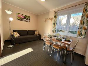 a living room with a couch and a table and chairs at Ptasi Raj in Karwia