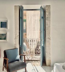Habitación con silla y ventana en Vittorio Veneto by Bed&Bros, en Siracusa