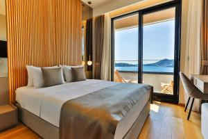 a bedroom with a large bed and a large window at Regent Resort Budva in Budva