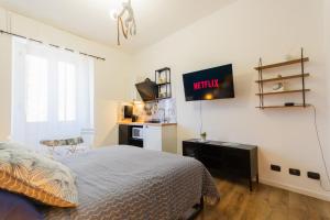 a bedroom with a bed and a tv on the wall at Casa Remy in Cagliari