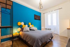 a bedroom with a blue wall and a bed at Casa Remy in Cagliari