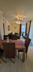 a living room with a table and chairs and a couch at Tamási Nyaralóház in Balatonmáriafürdő +23 photos