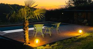 a deck with two chairs and a palm tree with lights at Charming Tuscan Suite with Pool 2 to 5 persons Lamole Greve in Chianti in Greve in Chianti