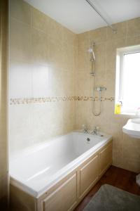 a bathroom with a white tub and a sink at Strelley house 4 , Perfect for business trip & Families holiday or working proffesionals-5 min from M1 J25 , 500MB Wi-Fi , Netflix , Fully equiped kitchen , Asda supermarket 5 min walk , Free Secure parking with CCTV ,available monthly deals in Nottingham +24 photos