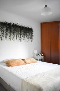 ein Schlafzimmer mit einem Bett mit Pflanzen an der Wand in der Unterkunft Royal House AL in Rio Caldo