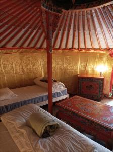 a bedroom with two beds in a yurt at Au Chat qui Pêche in Thenay