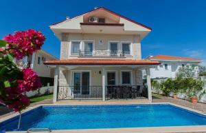 a villa with a swimming pool in front of a house at Villa carin in Ortaca