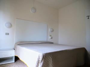 een witte slaapkamer met een bed en een witte muur bij LC Hotel by Gale in Lido di Camaiore +7 foto's