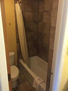 a bathroom with a tub and a toilet and a sink at Town House Motel in Tyler