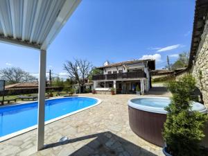a patio with a swimming pool and a house at Angliiska Vila in Arbanasi
