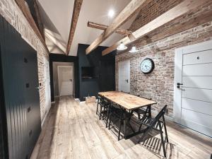 a dining room with a wooden table and a brick wall at Hostel 19 Sopot in Sopot