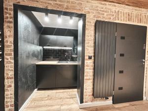 a kitchen with a sink and a brick wall at Hostel 19 Sopot in Sopot +154 photos