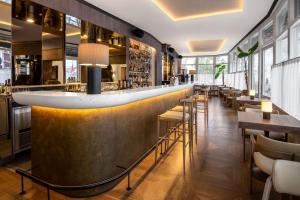 ヴィリニュスにあるRadisson Collection Astorija Hotel, Vilniusのテーブルと椅子のあるレストラン内のバー