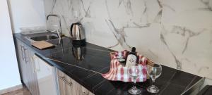a kitchen with a black counter top with wine glasses at Chrysiis House 2 in Maltezana +17 photos