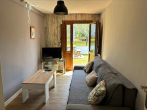 a living room with a couch and a table at Apartamentos Turísticos Casa Nieves in La Franca