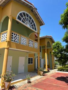 a house with yellow and green at Villa Azure in Tower Isle