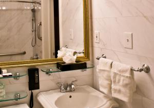 a white bathroom with a sink and a mirror at The Millwood in Millbrae