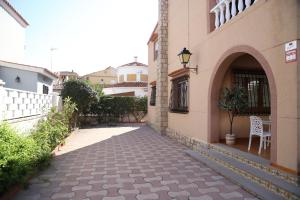 an alley with a building and a chair on the side at MD Chalet con piscina Mareny Beach in Mareny Blau