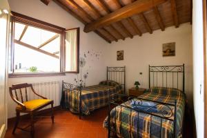 a room with two beds and a chair and a window at Agriturismo La Serra in Cenaia +54 photos