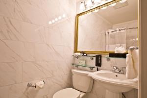 La salle de bains est pourvue de toilettes, d'un lavabo et d'un miroir. dans l'établissement The Millwood, à Millbrae