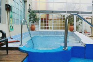 a swimming pool with a blue tub in a building at Hotel Semiramis Colonial in Termas de Río Hondo