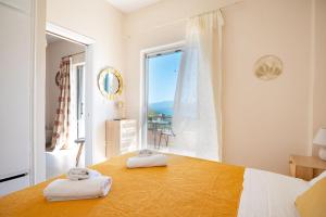 a bedroom with a bed and a large window at Agrili Sea View in Corfu
