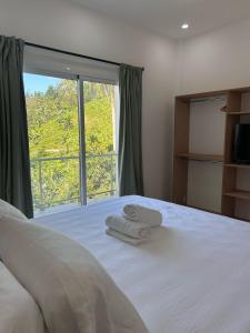 a bedroom with a bed with two towels on it at Refugio Verde Las Terrenas in Las Terrenas +3 photos