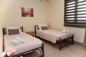 パレオカストリッツアにあるKineri Houseのタオルが敷かれたベッドが2つある部屋