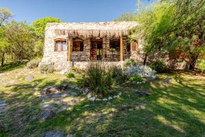 an old stone house in the middle of a yard at Habitaciones individuales o Dobles en La Llave in San Javier