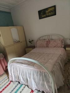 a bedroom with a bed with a white bed frame at Residencia Paris in Coimbra