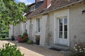 CormerayにあるLe Clos de la Fouasserieの白い扉と花の家