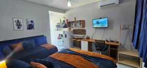 a bedroom with a blue couch and a desk with a computer at Studio Cinza em frente à praia in Aracaju