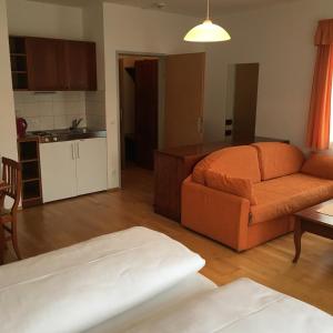 ein Wohnzimmer mit einem Sofa und einer Küche in der Unterkunft Sporthotel am Ötscher in Lackenhof