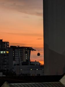 a sunset in a city with a building and a crane at Apartamento en Pereira - Pinares in Pereira