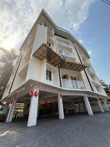 a large white building with a balcony at Stay Bridge Residency in Kozhikode