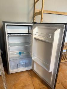 an empty refrigerator with its door open in a room at A 5 minutos de Ifema y 10 del aeropuerto, habitación y baño privado con entrada independiente in Madrid