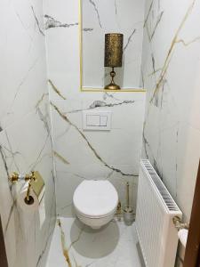 Baño blanco con aseo y lámpara en Rioba Chalet, en Nová Bystrica 34 fotos más