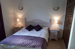 ein Schlafzimmer mit einem großen Bett mit zwei Nachttischen in der Unterkunft Villa Acebo in Nerja