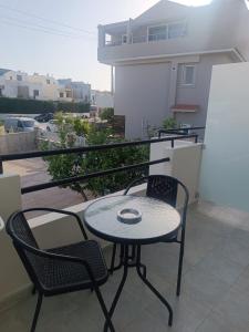a patio with a table and two chairs on a balcony at Iskas apartments in Ialysos