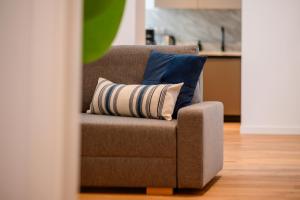 Exclusive 1BR Apartments in ONE Cotroceni في بوخارست: كرسي بني ومخدتين عليه