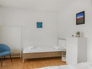 a bedroom with a bed and a blue chair at großzügiges Apartment I 10 Personen I Einzelbetten I Parkplatz I WLan in Alzey