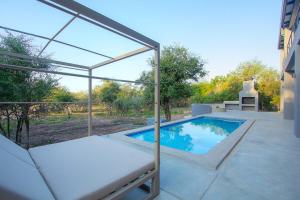 a swimming pool with a glass enclosure on a patio at Giraffe Oasis - Kruger Luxury Family Villa in Marloth Park