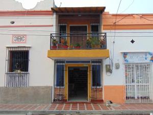 un edificio con puerta amarilla y balcón en Hostal Santa Maria City, en Santa Marta