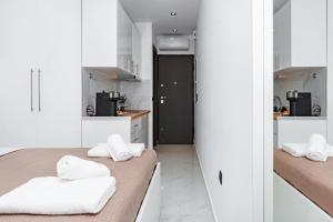two beds in a small room with white cabinets at Studio D1 in Kallithea Halkidikis