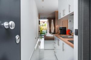 a kitchen with white cabinets and a sink at Studio D1 in Kallithea Halkidikis +5 photos